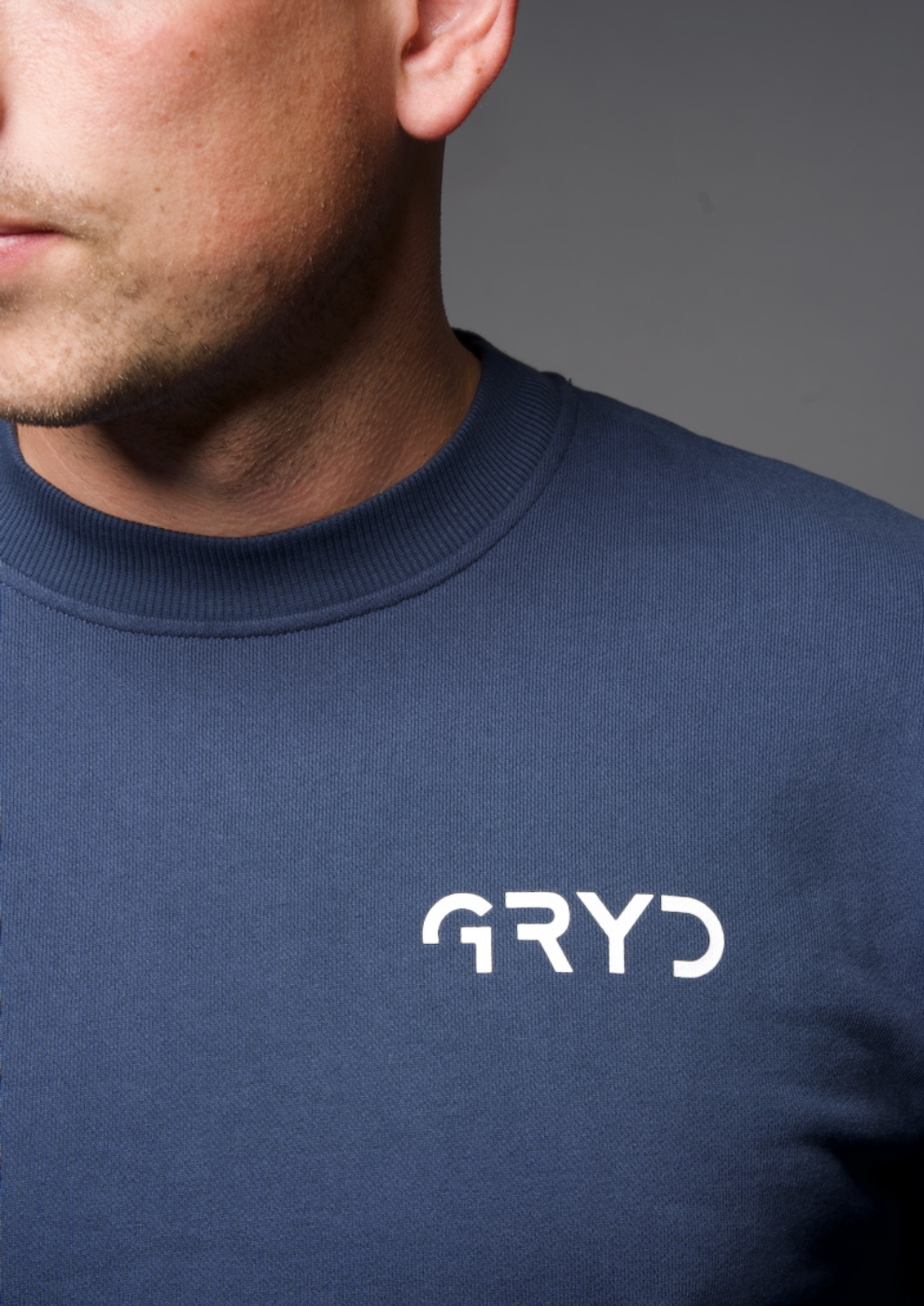 Navy blue sweatshirt with 'GRYD' logo worn by a person on a gray background